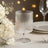 Elegant ribbed glassware on a dining table with floral accents and soft bokeh lights.