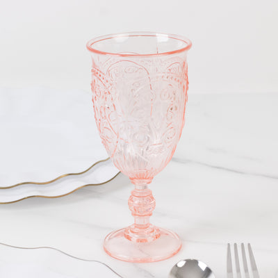 Pink decorative glass goblet on a marble surface.