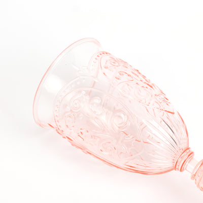 Pink decorative glass with intricate patterns on a white background.