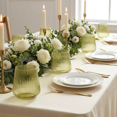 Elegant white floral candlelit table setting with gold accents and green glassware
