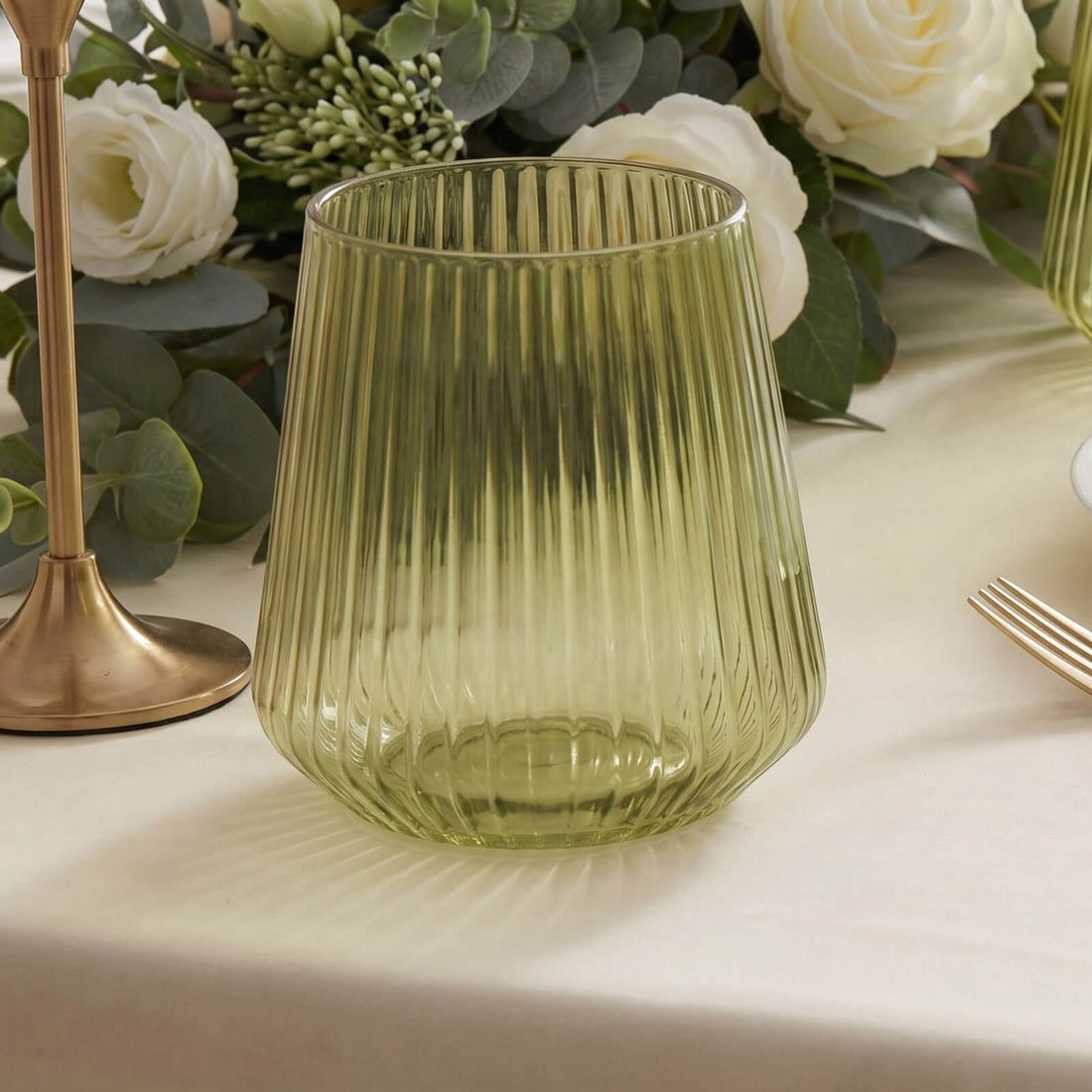 Green ribbed glass votive candle holder on elegant floral table setting
