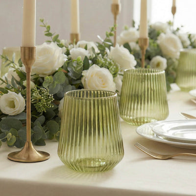 Elegant white floral table setting with green glassware and gold candlesticks
