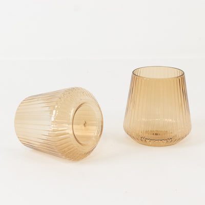 Two ribbed amber glass cups on a white background.