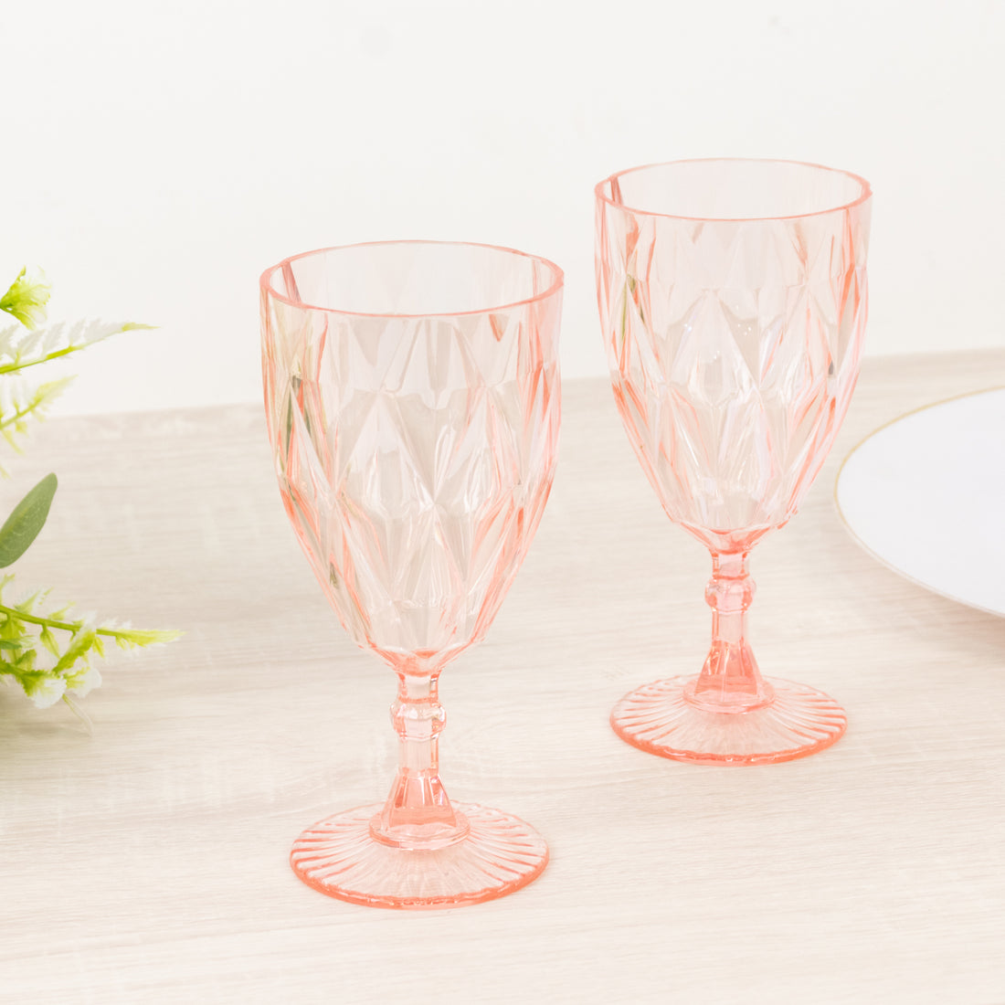 Set of two pink crystal goblets with a diamond pattern.