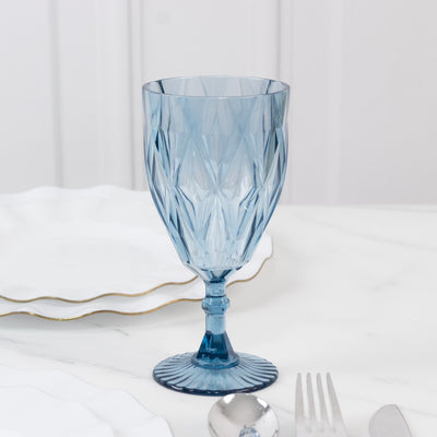 Blue crystal goblet with diamond cut design on a white background.