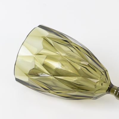 Green patterned champagne glass on a plain background