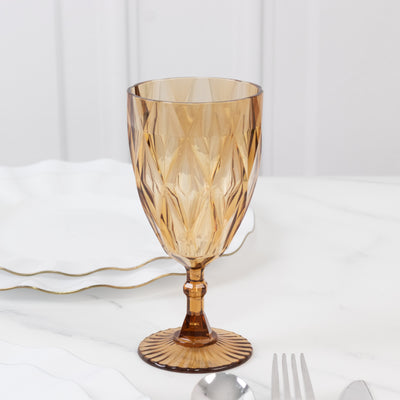 Amber crystal goblet with intricate diamond pattern on a marble surface.