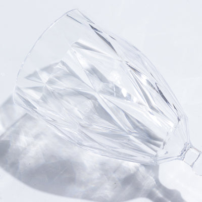Crystal cut glass wine glass on a plain background.