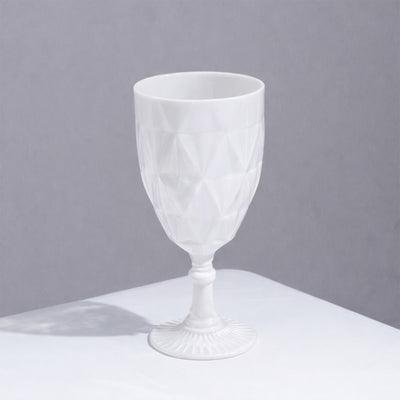 White geometric patterned goblet on a plain surface.