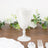 White textured plastic goblet on a wooden table with greenery