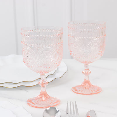Set of two vintage-inspired pink glass goblets on a marble table.