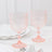 Set of two vintage-inspired pink glass goblets on a marble table.