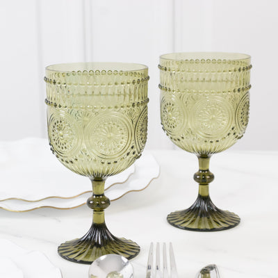 Green decorative goblets on a marble table setting.
