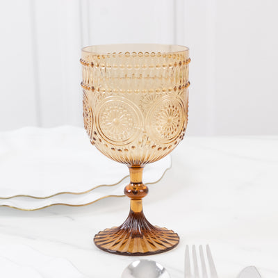 Amber glass goblet with intricate patterns and a decorative base.
