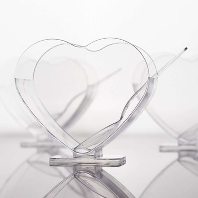 Clear heart-shaped serving dishes on a plain background.