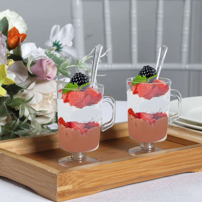 Two delicious parfaits with strawberries and cream served in clear cups on a wooden tray.