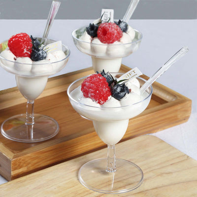 Delicious ice cream dessert topped with raspberries and blueberries in glass cups.