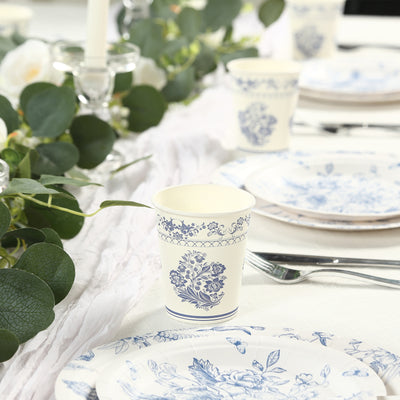 Elegant floral paper cup on a beautifully set table with plates and greenery.