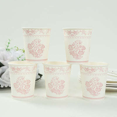 Stack of five decorative paper cups with floral designs on a plain background