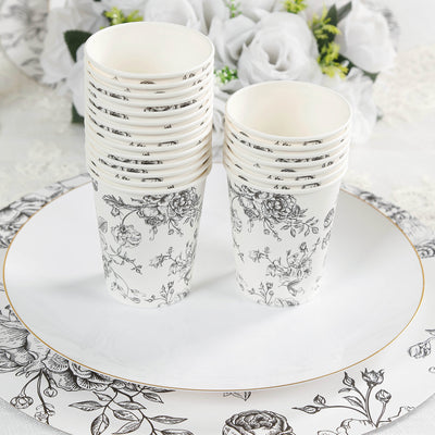 Stack of elegant floral paper cups on a decorative plate.