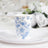 Floral-patterned paper cup on a white plate at a table setting.