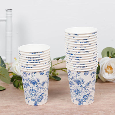 Stack of floral patterned disposable cups on a wooden surface.