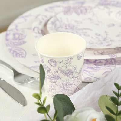 Floral-patterned paper cup with matching plates on a table setting.
