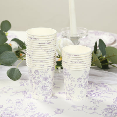 Stack of floral-patterned paper cups on a table with greenery.