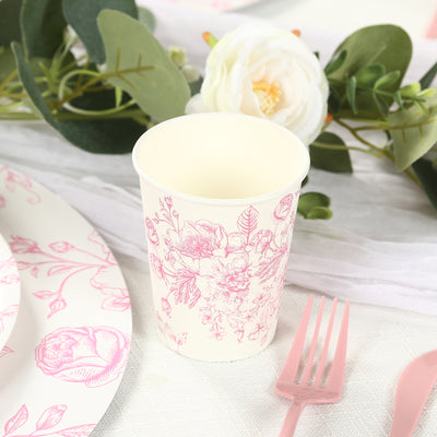 Floral pink paper cup on a table setting with plates and utensils.