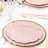 Pink decorative plates with a gold rim on a dining table setting.