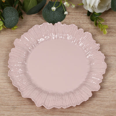 Pink decorative plate with a ruffled edge on a wooden surface.