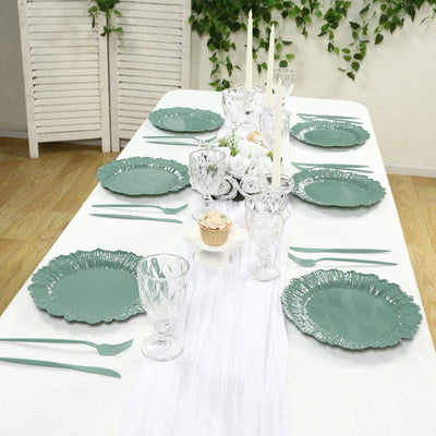 Elegant green dinnerware set arranged on a table with candles and decor.