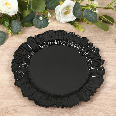 Black decorative plate with a ruffled edge on a wooden surface.
