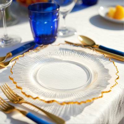 Elegant glass plate with gold rim on a beautifully set table.