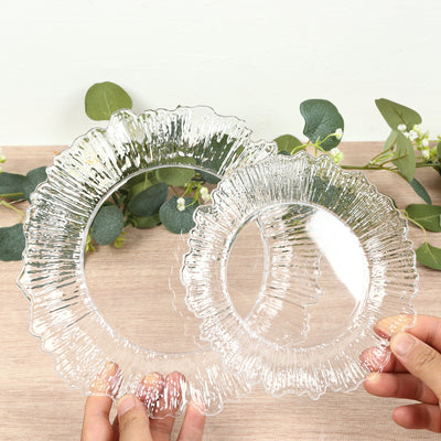 Clear decorative plates held with greenery in the background.