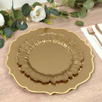 Gold decorative plates stacked on a wooden table with greenery accents.