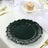 Black floral plate on a dining table with a cupcake and glassware.