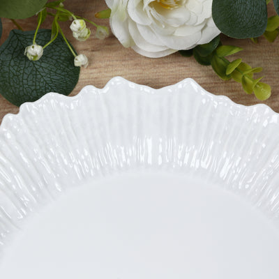 White decorative plate with textured rim on wooden surface.