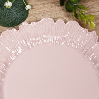 Pink decorative plate with a ruffled edge design.
