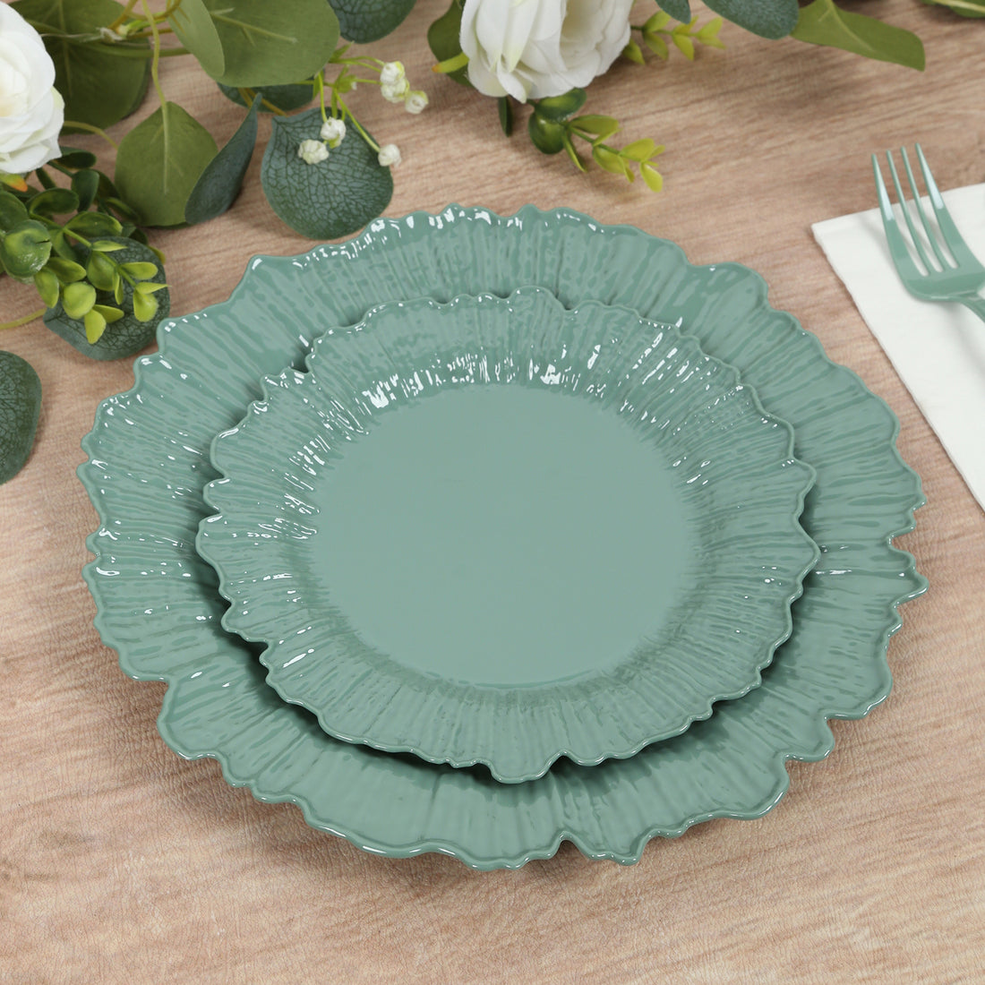 Set of three teal decorative plates with scalloped edges.
