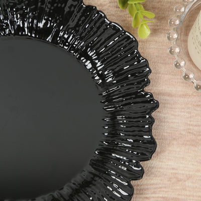 Black decorative plate with a wavy edge and glossy finish.