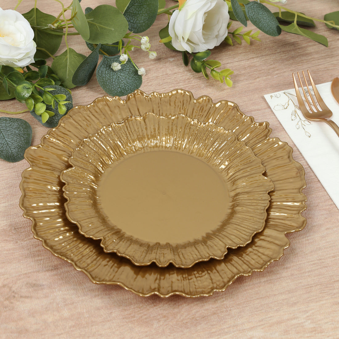 Gold decorative plates in layered design on a rustic wooden table.
