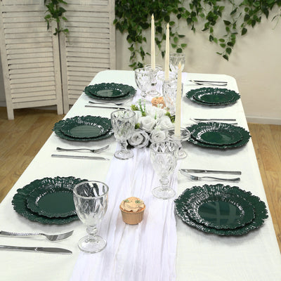 Elegant green dinnerware set on a beautifully arranged table with candles and floral decor.