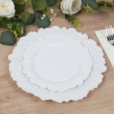 Three elegant white decorative plates stacked on a wooden table.