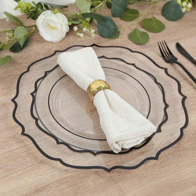 Elegant clear charger plate with black rim, styled with a napkin and gold ring.