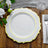 Elegant white plate with gold trim on a wooden table setting.