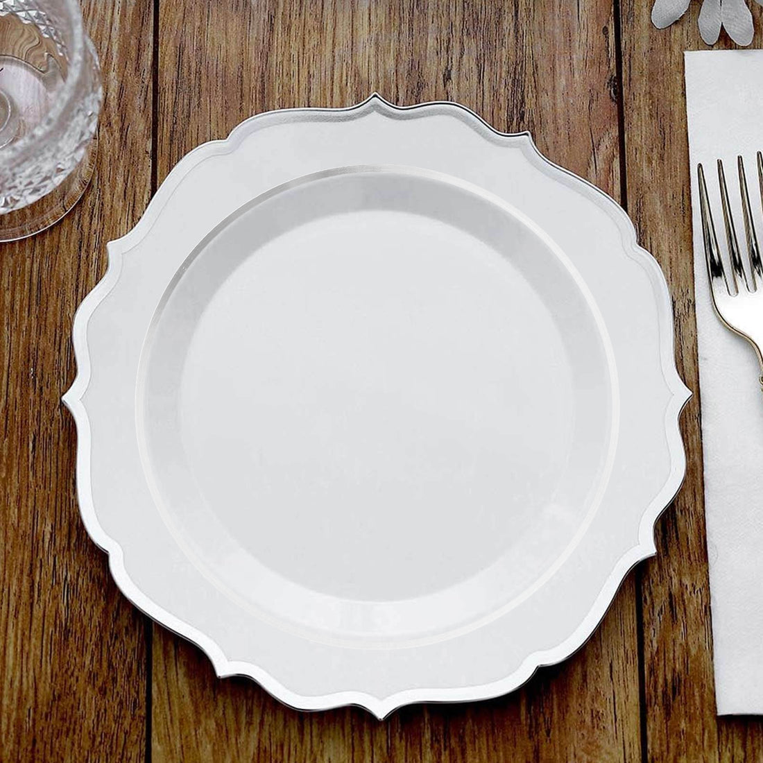 Elegant white plate with decorative edge on wooden table.