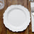 Elegant white plate with decorative edge on wooden table.