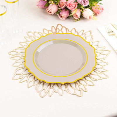 Elegant gold-trimmed plate on a decorative charger with a floral centerpiece.
