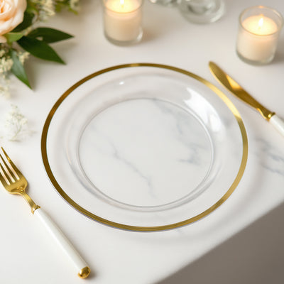 Elegant clear glass plate with gold rim, styled with cutlery and candles.